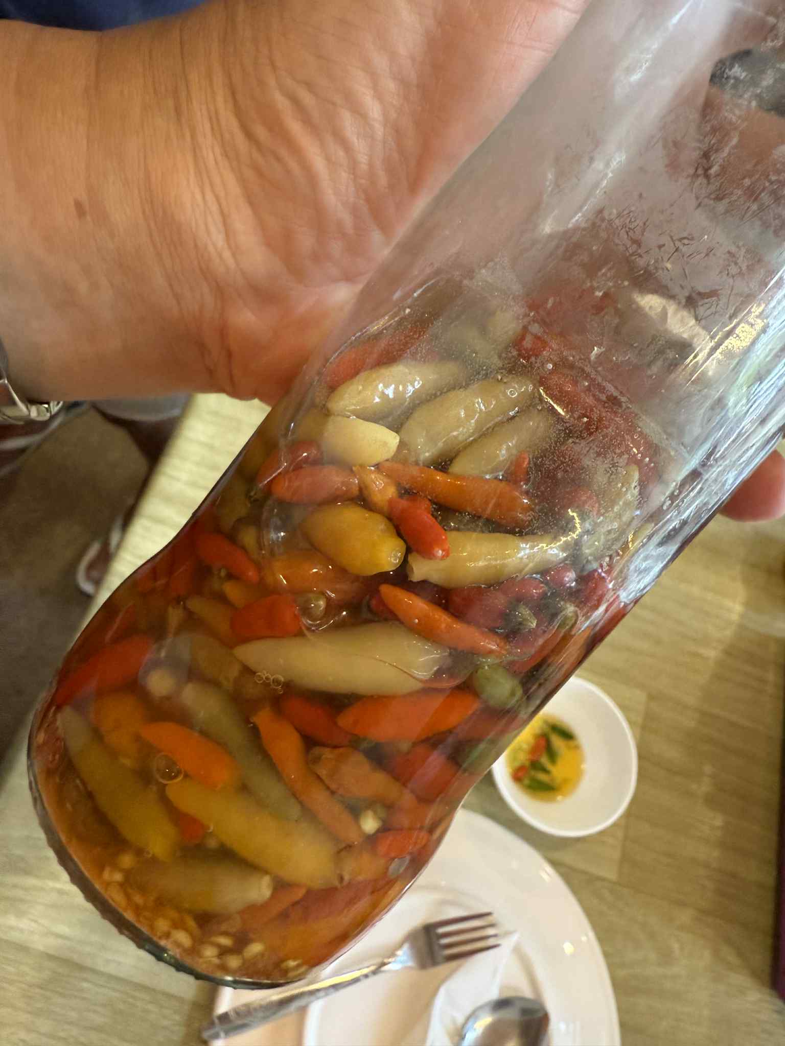 菲律賓 sili sa suka 辣椒醋，整條小辣椒浸泡在白醋中，呈現南島與港口飲食文化的典型酸辣調味。