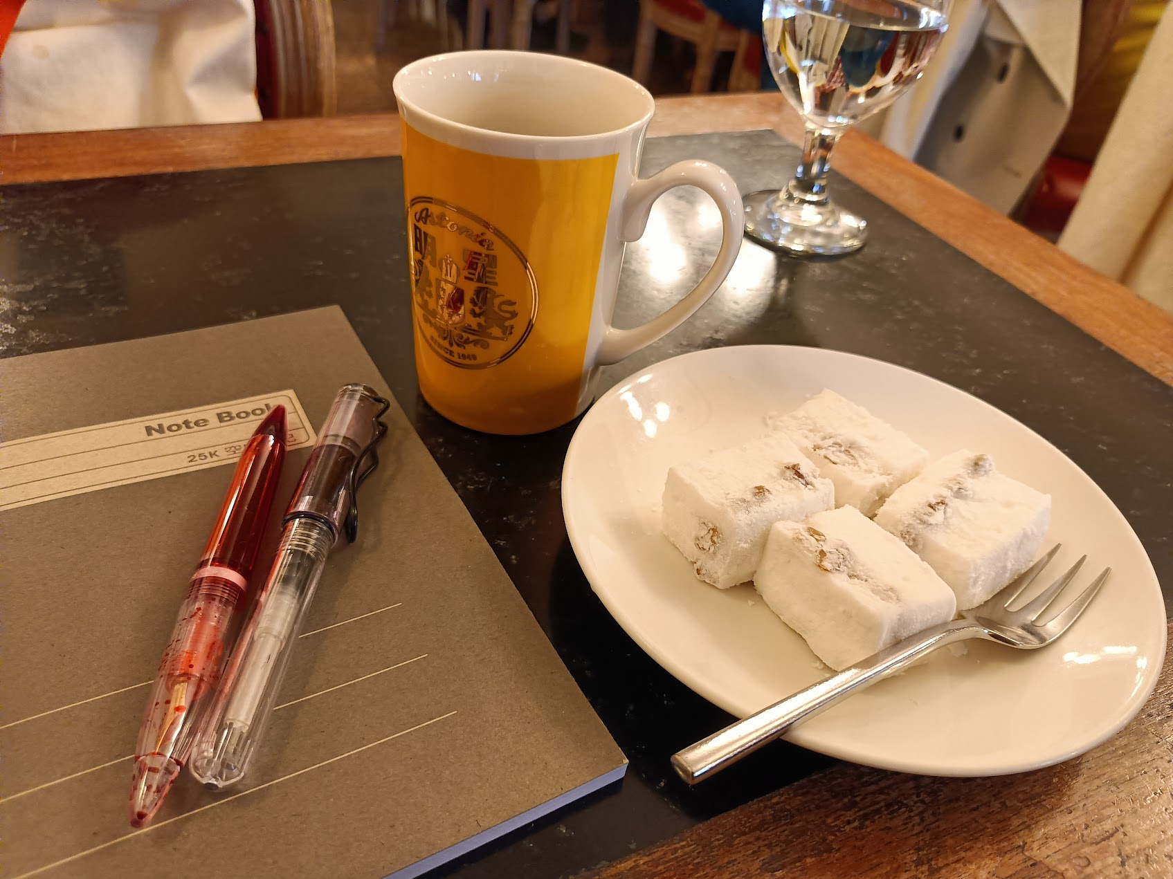 台北の明星咖啡館のテーブル風景。カップ、ノート、ペン、デザート皿が並び、古いロシア風カフェの都市的な記憶を感じさせる。