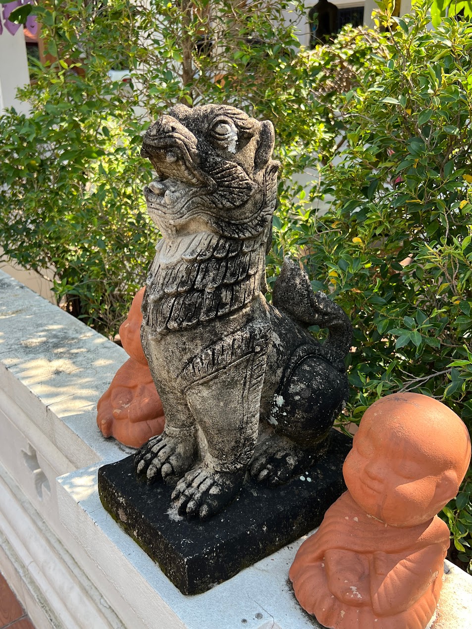Stone guardian lion with a small cub detail in Southeast Asian temple