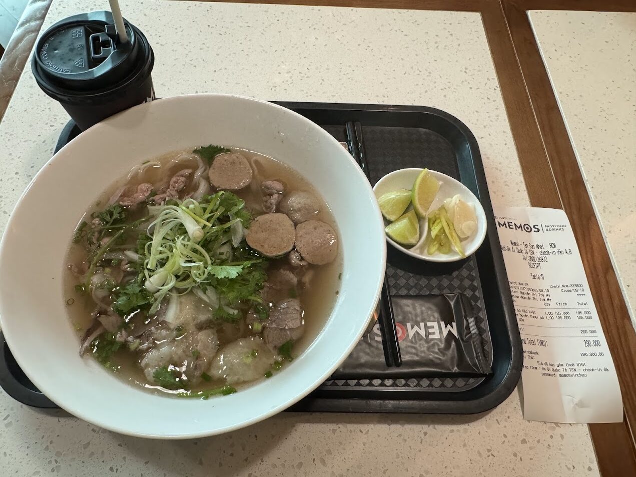 都市型のフォーのトレー。ライム、肉団子、付け合わせがあり、現代都市の中でもフォーが速く、しかし丁寧に組み立てられていることを示す。