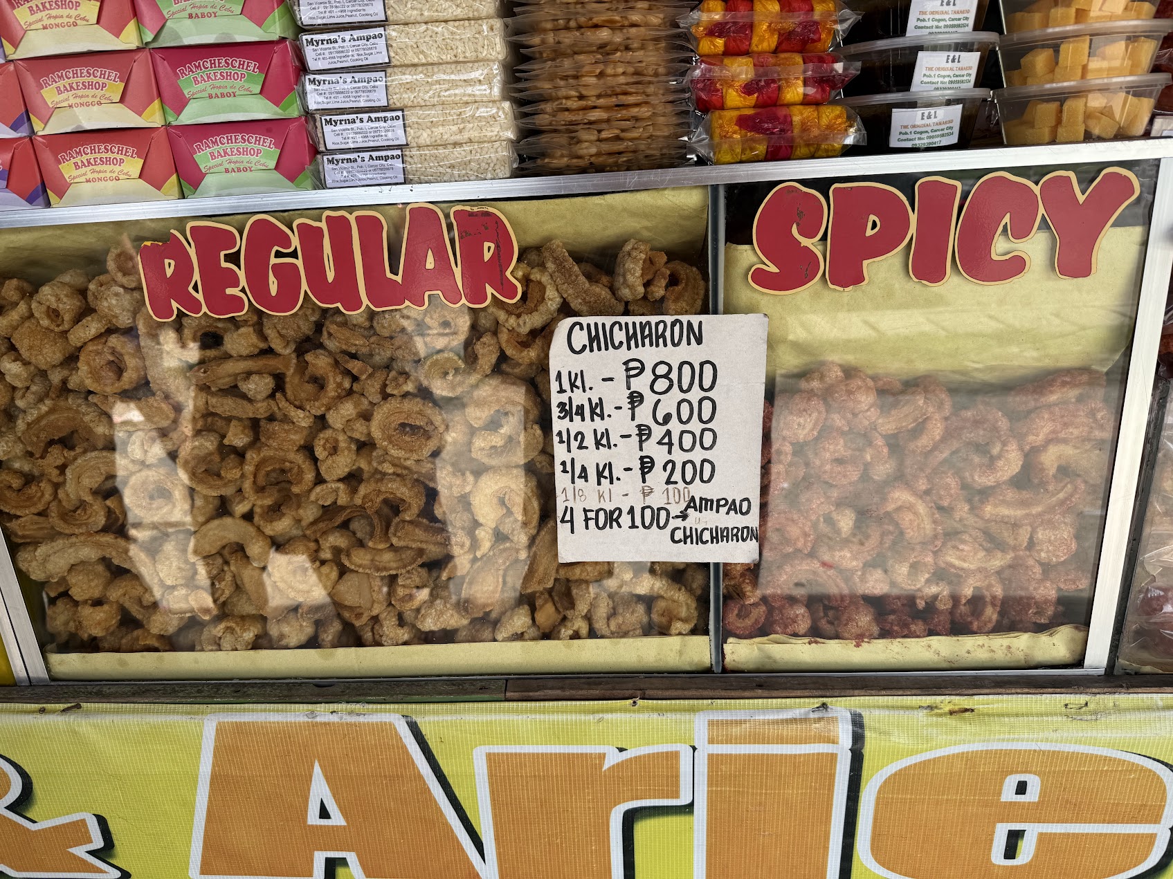 Carcar の店内に並ぶ regular と spicy の chicharon の陳列。価格と分類が明確に示され、地方商品の成熟した小売構造がわかる。