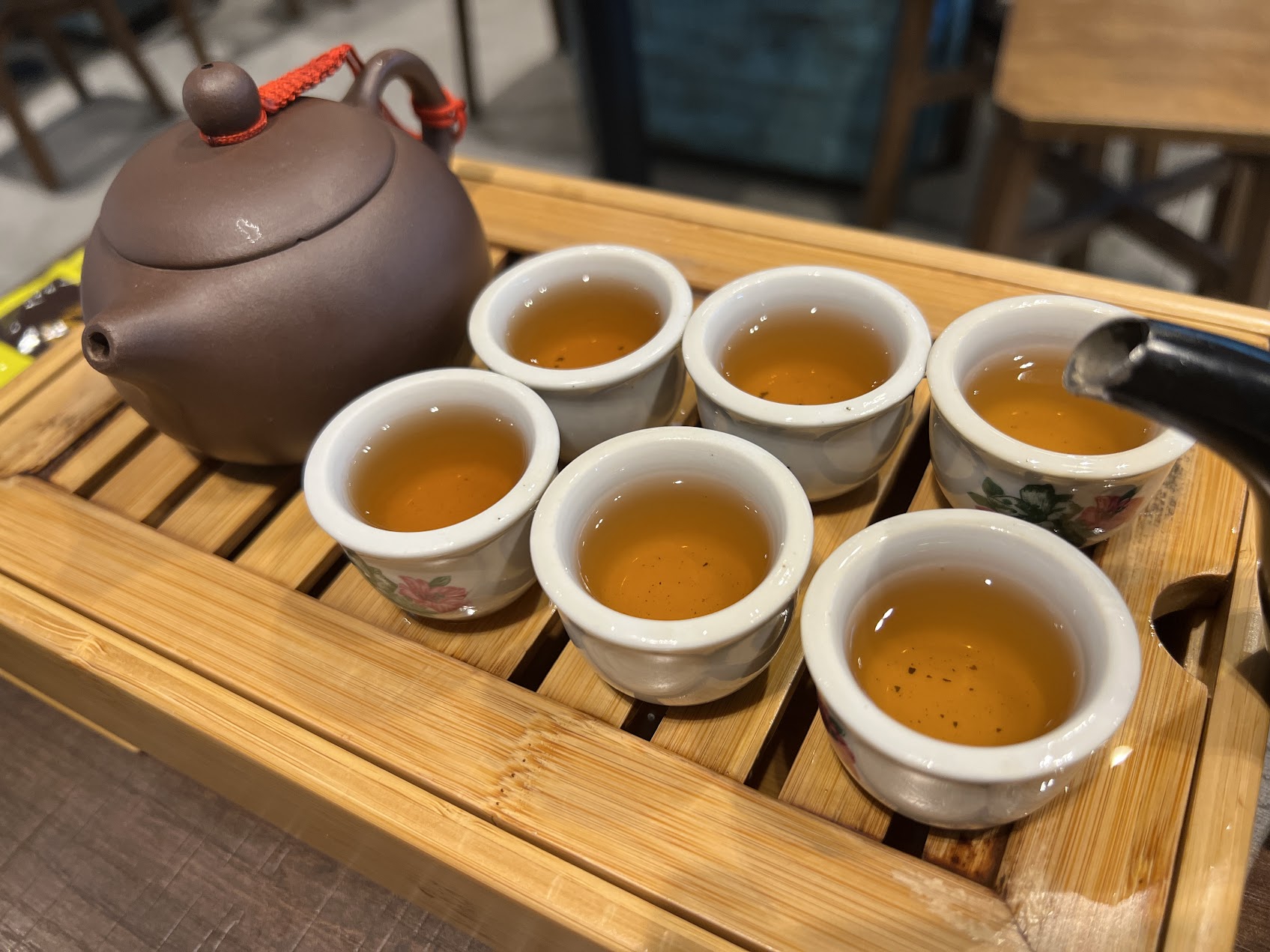 紫砂壺與多只茶杯共享一壺茶,呈現南方華人社會裡共飲、招待與餐桌節奏