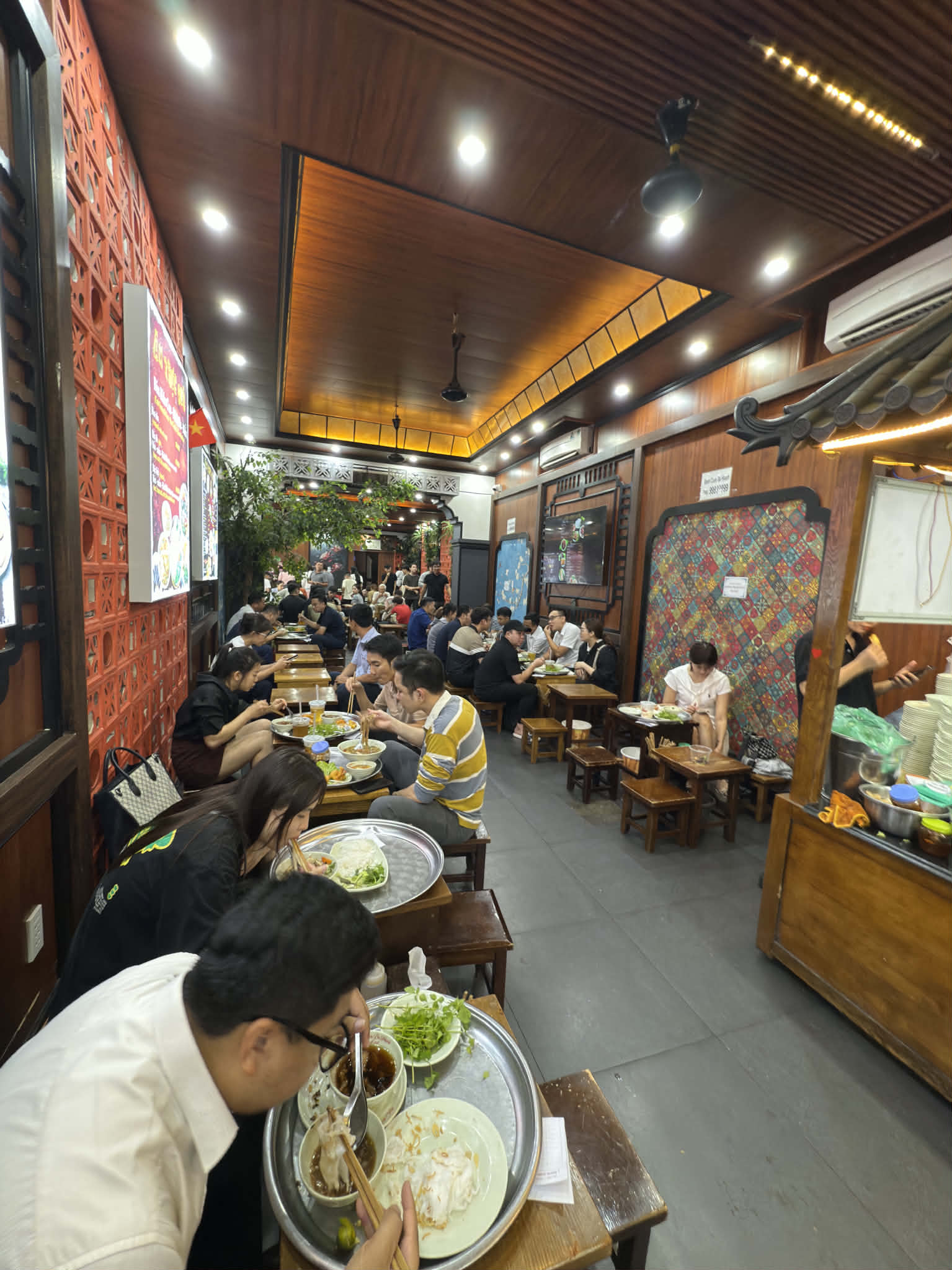 昼時のハノイのバインクオン店内。席の大半が埋まり、この米食がいまも地元の人びとの日常の食事に深く組み込まれていることがわかる。
