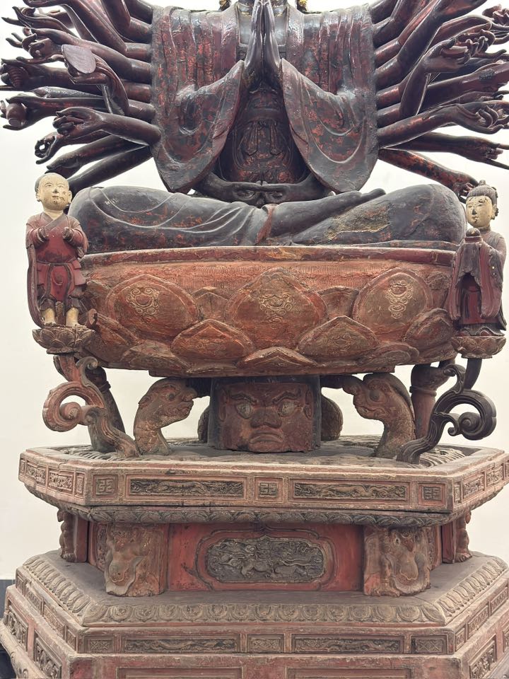 Close-up detail of the lotus pedestal and Nāga-supported base beneath the Hanoi museum’s Avalokiteśvara sculpture, showing how Buddhist compassion is structurally joined to local serpent guardianship.