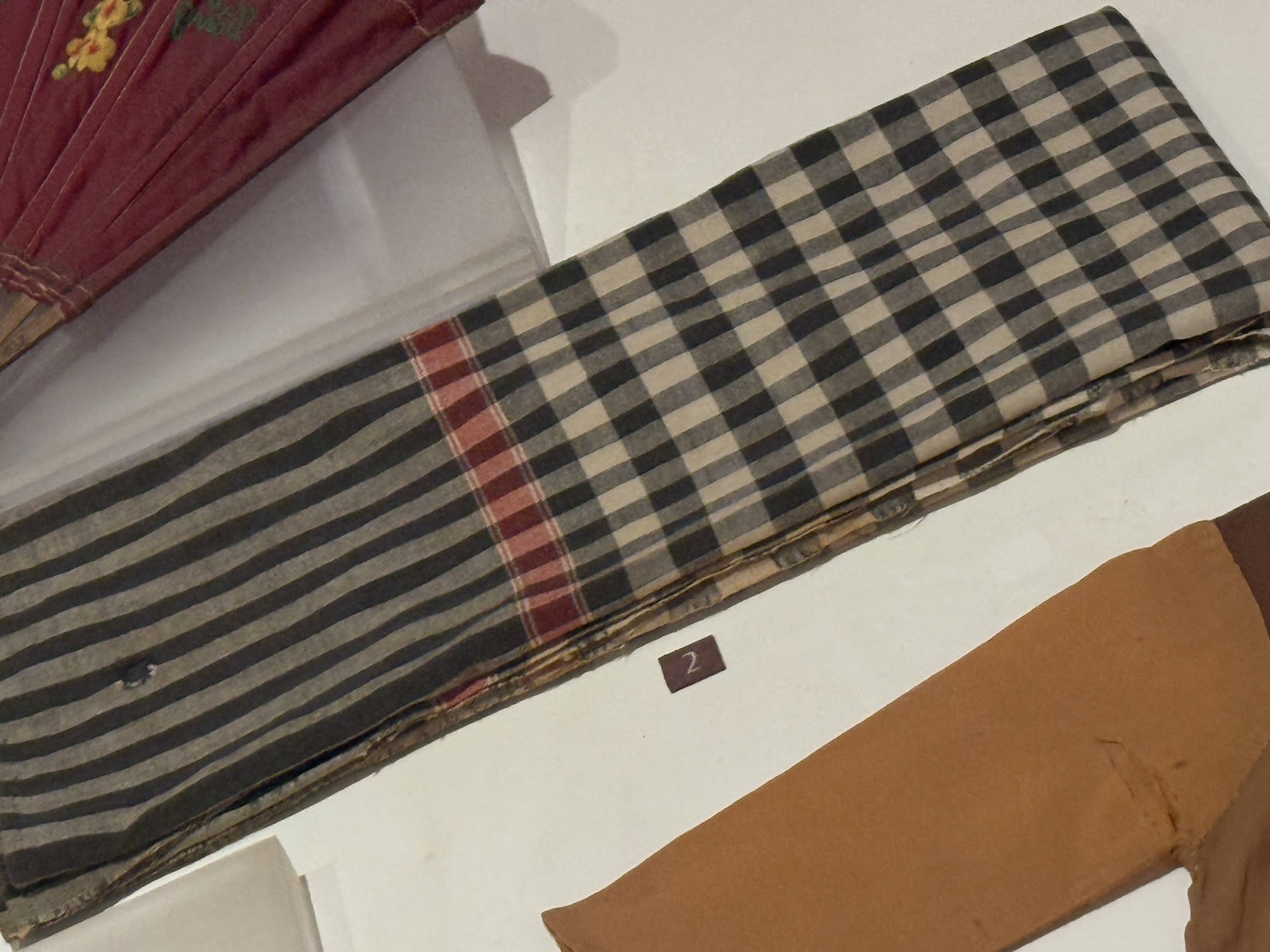 Khăn Rằn displayed at Hanoi Women’s Museum, a black-and-white checked scarf once used by a woman in prison as a menstruation pad, bearing visible signs of age and wear