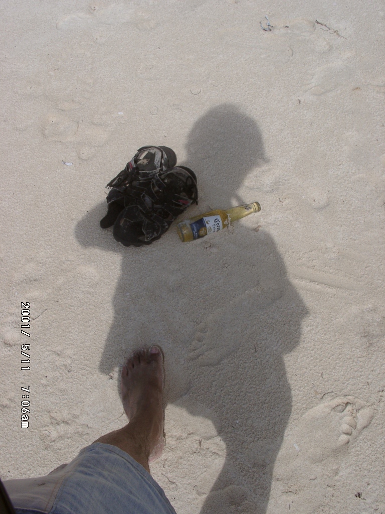 2001年、海辺に落ちた影と靴とビールのボトル。旅の途中の静かな一瞬。