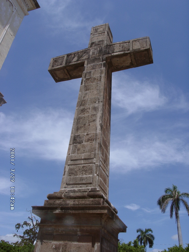 A colonial stone cross in Granada, Nicaragua standing in open space, showing how Catholicism entered local landscape and became a public sacred landmark.