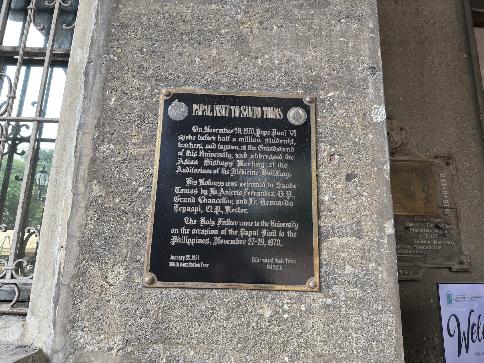 Papal visit plaque at the University of Santo Tomas in the Philippines, showing the formal connection between Philippine Catholicism and the wider center of the global Church.