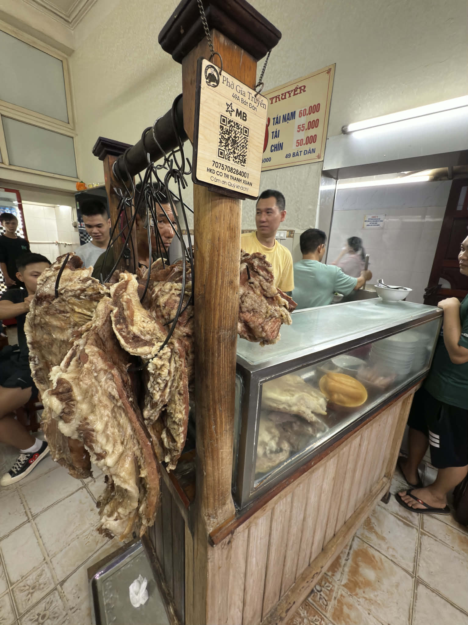 ハノイのフォー・ザー・チュエン店内に吊るされた牛骨とカウンターの作業風景。フォーの背後にある素材、労働、店の動線が見えてくる。