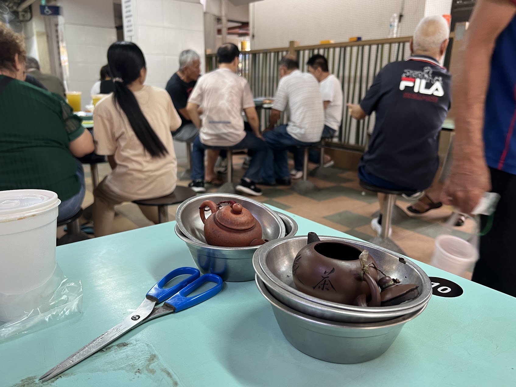 餐館桌上擺著紫砂壺與茶具,呈現茶在庶民飲食空間中的日常存在