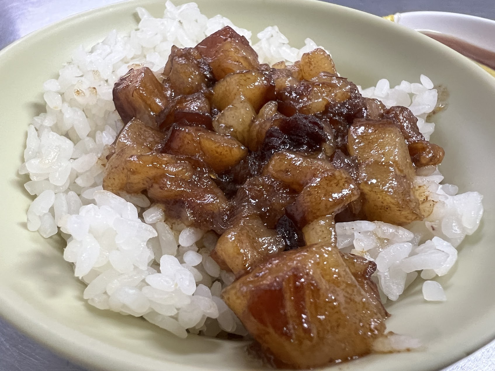 白いご飯の上に艶のある細かい煮込み豚肉がのり、煮汁がうっすらと染み込んだ、北部でよく見られる魯肉飯の形。