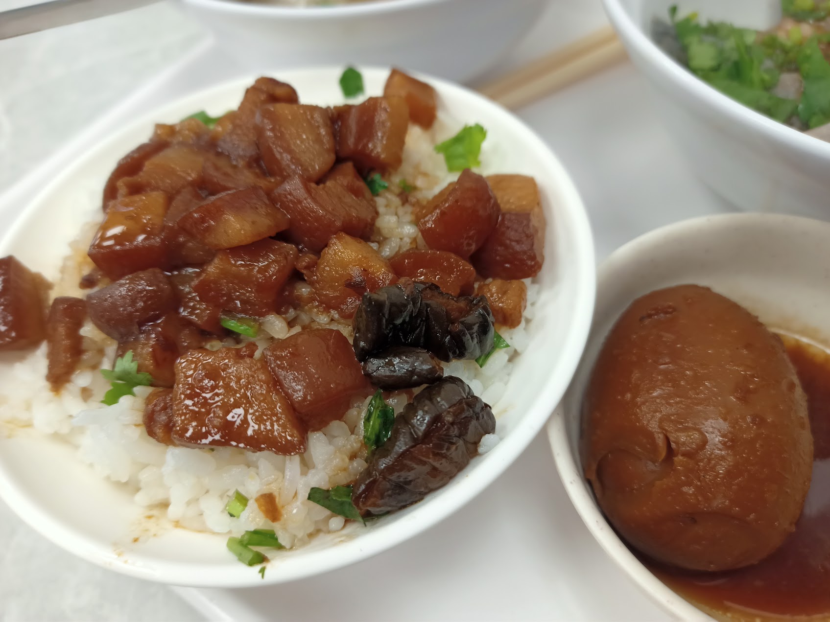 白いご飯の上に細かい煮込み豚肉と煮卵がのった、台湾北部でよく見られる魯肉飯の一例。