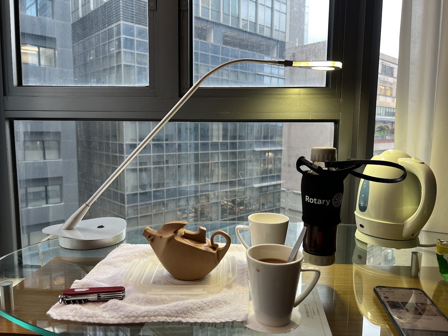 旅途中靠窗的小茶桌與城市景色,呈現異地停留時以一壺烏龍茶安頓身心的日常場景