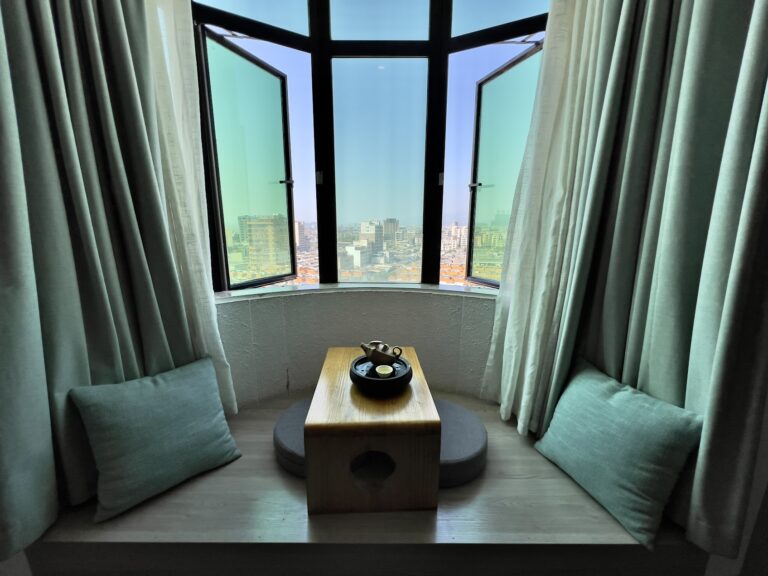 窗邊座位上的旅行茶席與茶具，呈現人在異地停留時以泡茶安定心緒的片刻