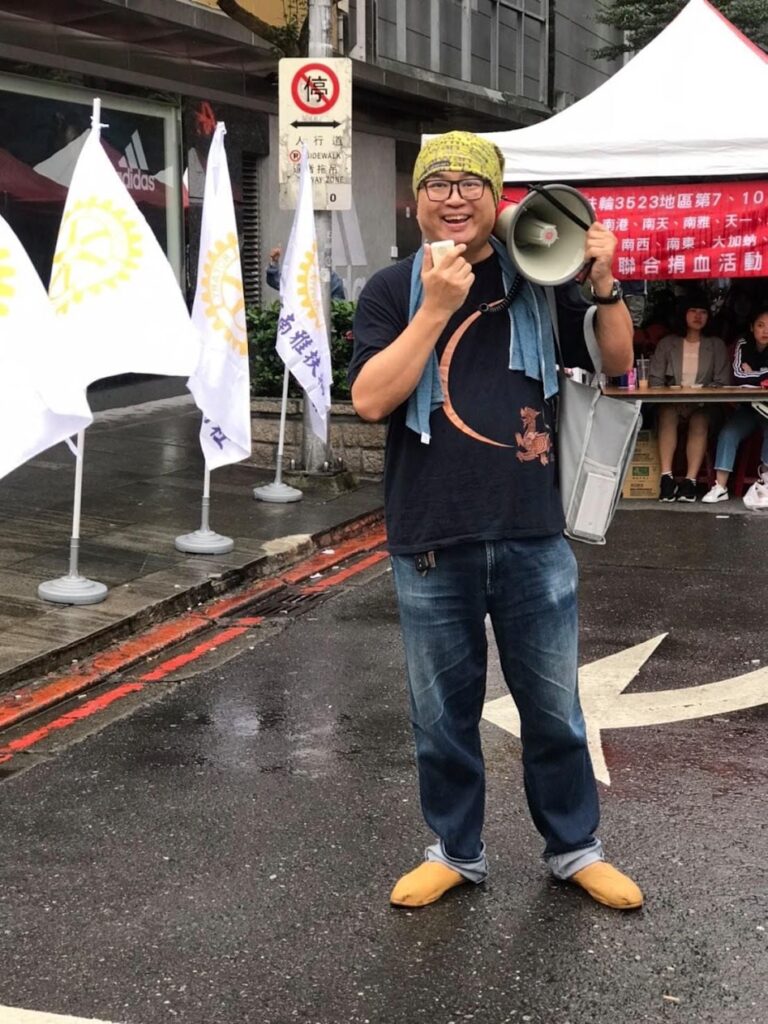 周端政持擴音器於 3523 地區聯合捐血活動街頭帶隊